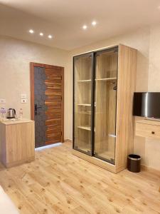 Una habitación con cocina con suelo de madera y puerta de cristal. en Cleo Patra Pyramids Tower Inn, en Banī Ghālib