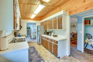 a kitchen with a sink and a refrigerator at 8 Mi to Crystal Mountain Peaceful Up North Home in Thompsonville