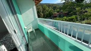 a balcony of a house with a chair on it at Cantinho aconchego gc in Ubatuba