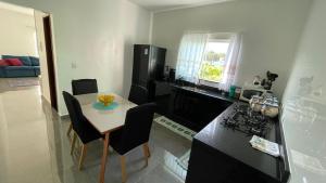 a kitchen with a table and chairs and a kitchen with a counter at Cantinho aconchego gc in Ubatuba