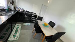 a kitchen with a table and chairs and a sink at Cantinho aconchego gc in Ubatuba +5 photos