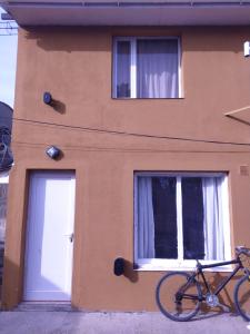 una bicicleta estacionada al lado de un edificio con dos ventanas en Hola Río Gallegos! Temporario, en Río Gallegos 2 fotos más