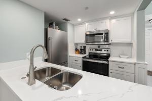 a kitchen with a sink and a stainless steel refrigerator at Shipwatch #102 in Saint Simons Island