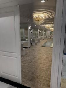 a large room with white chairs and a chandelier at ذا جولد للشقق المخدومة in Jeddah