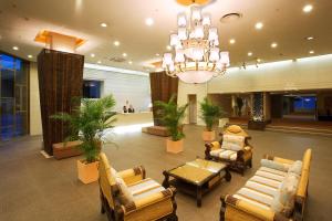 un vestíbulo con sillas, mesas y una lámpara de araña en Resort Hotel Tateshina, en Chino