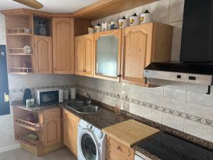 a kitchen with a sink and a washing machine at Casa Ferrero Salvador in Bolea