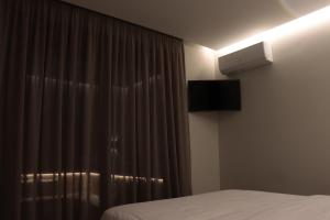 a bedroom with a bed and a window with curtains at Fos Luxury Villas in Karistos