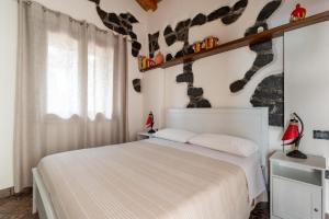 a bedroom with a white bed and a window at Terre Villa Katia in Santa Maria di Licodia