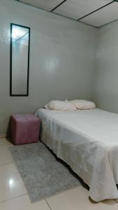 Un dormitorio blanco con una cama y un espejo. en Habitacion sencilla, en San Salvador