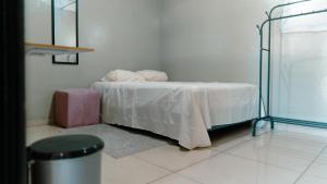 Habitación con cama con sábanas blancas y mesa. en Habitacion sencilla, en San Salvador