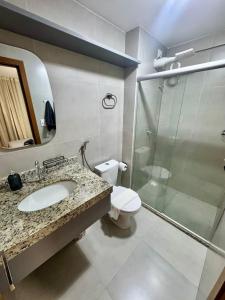 a bathroom with a toilet and a sink and a shower at UNU 602 Itapuã: piscina, academia, praia e+ in Salvador