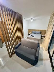 a bedroom with a bed and a couch in it at UNU 602 Itapuã: piscina, academia, praia e+ in Salvador