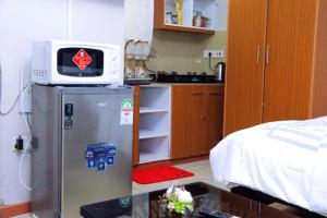 eine Küche mit Kühlschrank und Mikrowelle in der Unterkunft Betty Homes in Nairobi + 4 Fotos