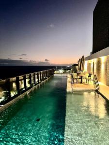 a swimming pool with a view of the ocean at UNU 602 Itapuã: piscina, academia, praia e+ in Salvador