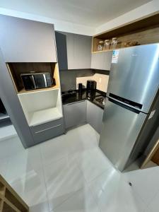 a kitchen with a stainless steel refrigerator and a microwave at UNU 602 Itapuã: piscina, academia, praia e+ in Salvador +19 photos