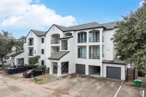 a large white building with a car parked in a parking lot at The Calvin 335 I Spacious 2 Bed 1 Bath in Plano