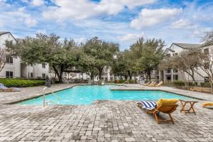 a swimming pool with a chair and a table at The Calvin 335 I Spacious 2 Bed 1 Bath in Plano