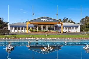 a large building with a marina with boats in the water at Byer Fountain Motor Inn in Holbrook