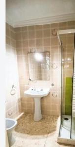 Un baño con lavabo, espejo y ducha. en Punta Umbria beach house, en Punta Umbría