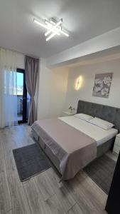 ein Schlafzimmer mit einem großen Bett und einem Deckenventilator in der Unterkunft Coquette Appart in Eforie