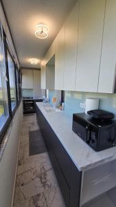 eine Küche mit weißen Schränken und einer schwarzen Mikrowelle in der Unterkunft Coquette Appart in Eforie