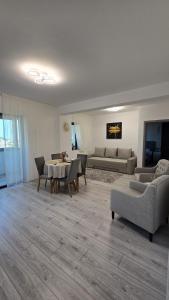 ein Wohnzimmer mit Sofa, Tisch und Stühlen in der Unterkunft Coquette Appart in Eforie + 9 Fotos