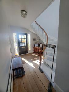 a staircase in a house with a wooden floor at Captain Hugo's Guesthouse in Rockland