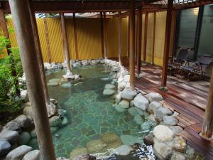 a swimming pool in a house with a wooden deck at Resort Hotel Tateshina in Chino