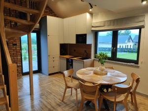 a kitchen and dining room with a table and chairs at Domki Karkonosze Pod Dębem in Wojcieszyce