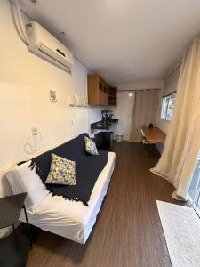 un soggiorno con un letto e una cucina di Flat dos Solteiros na Villela Stay Lago Sul DF a Brasilia