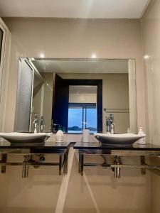 a bathroom with two sinks and a large mirror at Résidence calme et luxueuse in Dar Bouazza