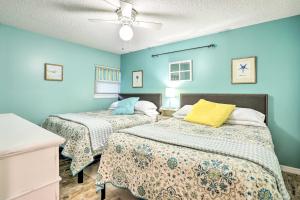 Dos camas en una habitación con paredes azules. en St Augustine Beach Condo with Patio and Pool Access!, en Butler Beach 30 fotos más