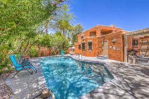 a swimming pool with a blue chair and a house at The Oasis At The Lakes in Las Vegas