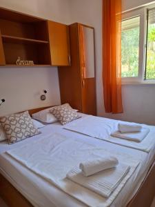 a bedroom with two beds with towels on them at Apartmani Ana i Mia in Ston