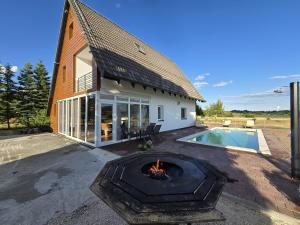 a house with a fire pit next to a swimming pool at Villa Vucipolje in Posušje