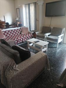 a living room with couches and a flat screen tv at Mitropoli's Home in Leonidion