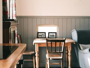 ein Esstisch mit zwei gerahmten Bildern darauf in der Unterkunft Southfield Cottage in Braunston