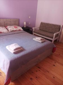 a bedroom with two beds and a bench with towels at Mitropoli's Home in Leonidion