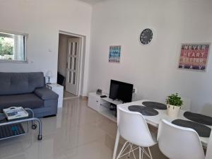 a living room with a couch and a table and chairs at Apartmani Ana i Mia in Ston