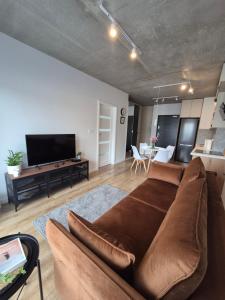 a living room with a couch and a flat screen tv at VizzitUs Premium Apartament Łódź Manufaktura in Łódź