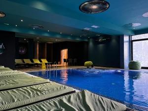 a large swimming pool in a room with blue ceilings at Kop Čardaci apartman Petković in Kopaonik