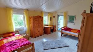 a bedroom with a bed and a dresser and two windows at Ruhiges Ferienhaus in sonniger Lage in Lissendorf