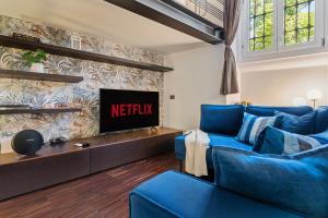 a living room with a blue couch and a tv at Milano Wellness Suite - Spa, Sauna & Gym Experience in Milan