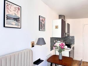 a living room with a couch and a vase of flowers on a table at Mondétour Paris centre - Urban flat in Paris