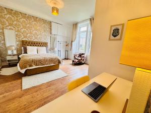 a bedroom with a bed and a desk with a laptop at THE RESTING LION - Gourock Town Center Holiday Home Apartment in Gourock +41 photos