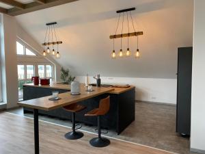 an open kitchen with a wooden table and chairs at Hengstresort Velten in Velten