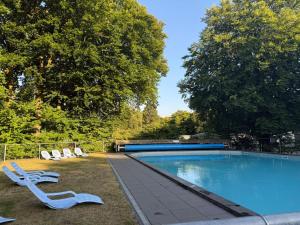 a swimming pool with two lounge chairs next to it at Chalet Wismar in Rijen
