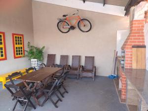 an orange bike hanging on a wall with a table and chairs at Casa Camioto in Olímpia