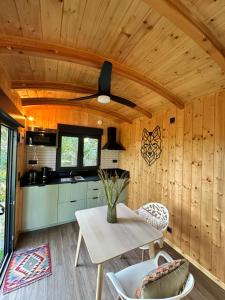 a kitchen with a table and a ceiling fan at The Green Wagon Costa Brava, Piscina Privada, AC, WIFI, Parking, Terraza in Tordera