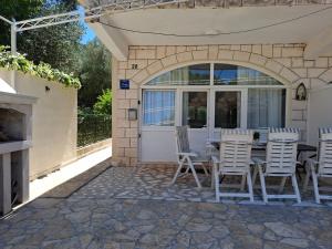 a patio with a table and chairs in front of a door at Apartmani Ana i Mia in Ston